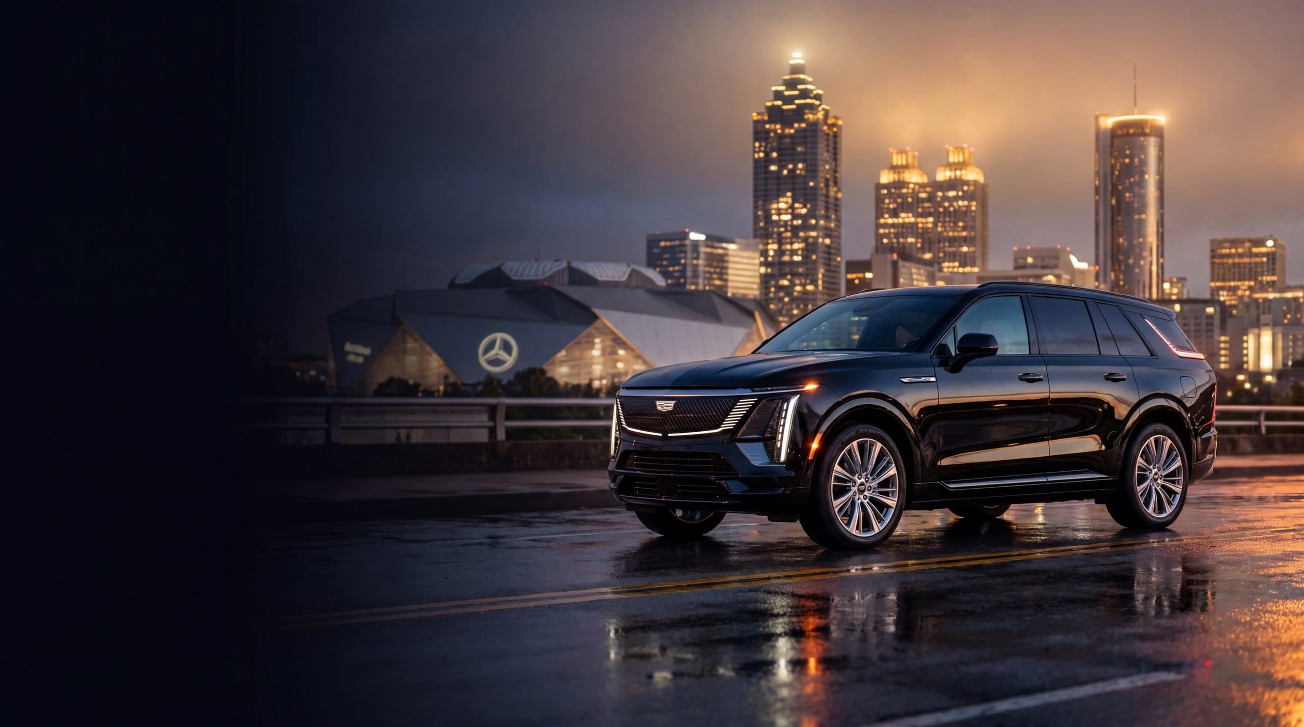 Black luxury vehicles in front of the Atlanta skyline at night